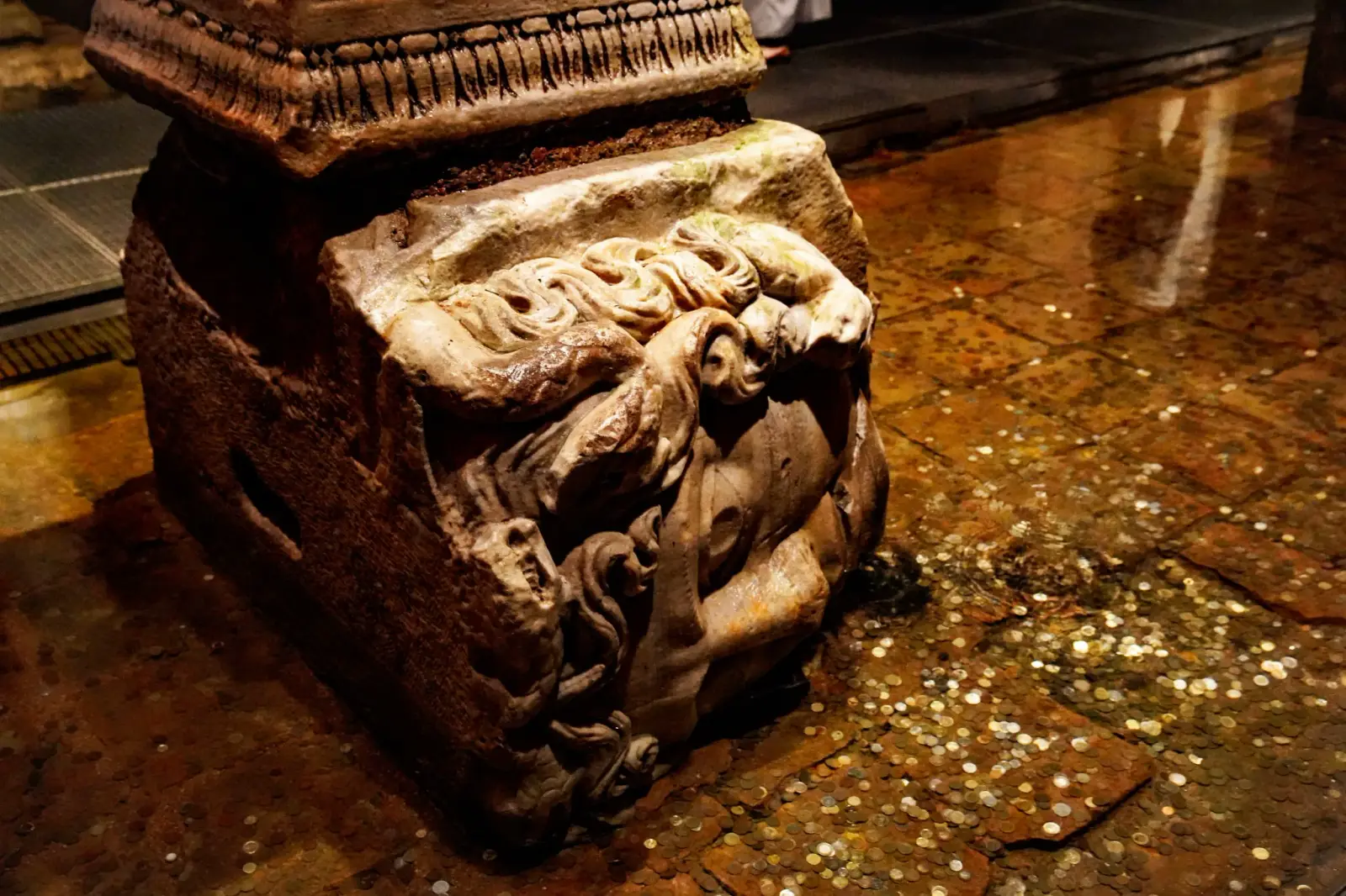 Carved marble Medusa head column base placed sideways inside the Basilica Cistern